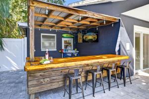 a wooden bar with stools at a patio at Steps to beachTiki BarHeated Poolfun! in Clearwater Beach