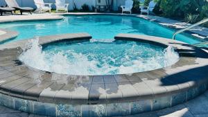 a swimming pool with a fountain in the middle at Steps to beachTiki BarHeated Poolfun! in Clearwater Beach +41 photos