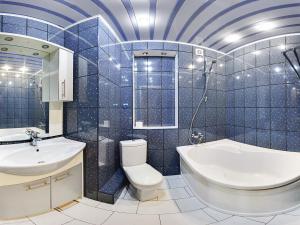 a blue tiled bathroom with a toilet and a sink at Two-bedroom Apartment on Pushkinskaia 54 in Kharkiv