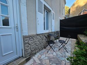 a patio with two chairs and a door at Le CASTEL 22 in Châteaumeillant