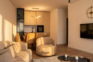a living room with a couch and chairs and a table at Inviti Apartments in Gjakove +1 photo