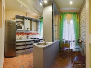 a kitchen with a sink and a refrigerator and a table at Two-bedroom Apartment on Pushkinskaia 54 in Kharkiv