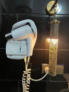 a white phone hanging on a wall next to a lamp at Dar Albanin in Fez