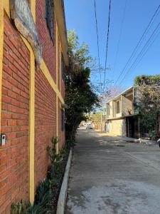 an empty street next to a brick building at Tu casa Oaxaca... in Oaxaca City