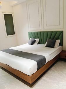 a bedroom with a large bed with a green headboard at Hotel Classio Ali Asgar in Jaorā