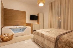 a bedroom with a tub and a bed and a television at Salerno casa con jacuzzi privata e cinema in Salerno