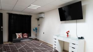 a room with a tv on the wall and a couch at Comfortable and Centrally Located Accommodation 2 in Altamira