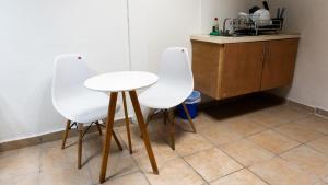 two white chairs and a table in a kitchen at Comfortable and Centrally Located Accommodation 2 in Altamira