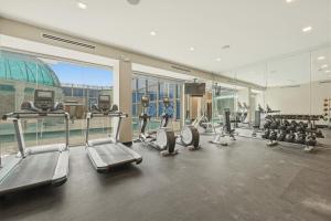 a gym with treadmills and cardio equipment in a building at Grand Tuscany Hotel in Houston