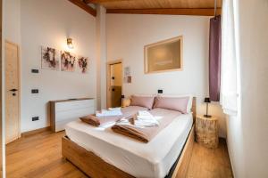 a bedroom with a large white bed with pink pillows at Country Life Chalet in Tione di Trento