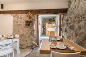 a kitchen and dining room with a stone wall at Country Life Chalet in Tione di Trento