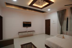 a bedroom with a bed and a tv on the wall at YR sea resort in Pāmban