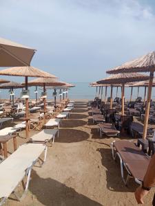 a row of chairs and umbrellas on a beach at Artemida Beach Apartment 2 in Artemida