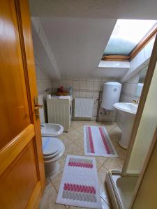 a bathroom with two toilets and a sink at Stan na dan Cazin in Cazin