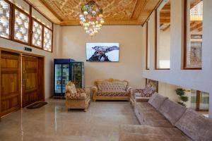 a living room with a couch and chairs and a chandelier at SHakhina premium hotel in old city in Bukhara