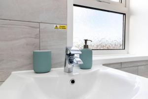 a bathroom sink with a blue soap dispenser on it at Durham 5BR Contractors Long Stay Discounts in Murton +27 photos