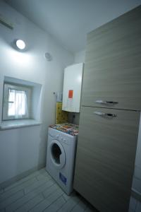 a laundry room with a washing machine and a washer at Mosahouse in Naples