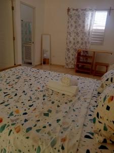 a bedroom with a bed with a flowered bedspread at MK apartment in Las Terrenas