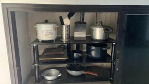 a shelf with pots and pans and other kitchen items at Digong Guest House Mulogan in Molugan