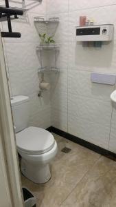 a white bathroom with a toilet and a sink at Digong Guest House Mulogan in Molugan +12 photos