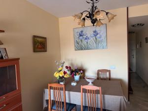 a dining room with a table with flowers on it at Apartamento Torrox5 in Torrox Costa +17 photos