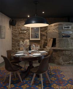 a dining room with a table with chairs and aendant light at A Casa do Tella e Rosalía in Portosin