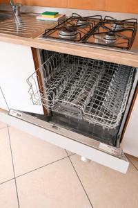 an empty dishwasher in a kitchen with a stove at Kai beach in Villa Rosa