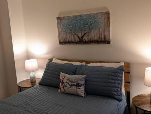 a bedroom with a bed with two lamps and a painting at Premium 3 Bed Top Floor Views in Vernon Township +25 photos