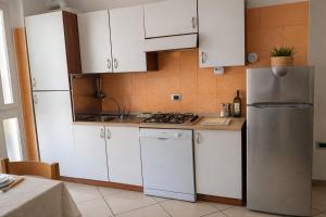 a kitchen with white cabinets and a stainless steel refrigerator at Kai beach in Villa Rosa