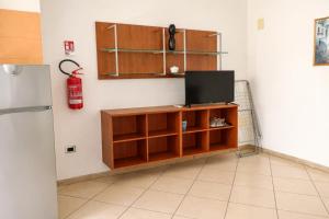 a living room with a tv and a fire extinguisher at Kai beach in Villa Rosa