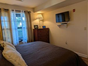 a bedroom with a bed and a tv on the wall at Country Charm 1 Bd Balcony Views in Vernon Township +13 photos