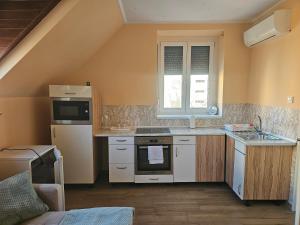 a small kitchen with a stove and a refrigerator at Bástya Hotel in Makó