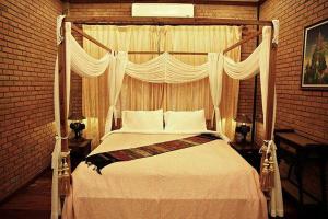 a bedroom with a white bed with a canopy at Chuanthanapanya Resort in Amphoe Sawang Daen Din