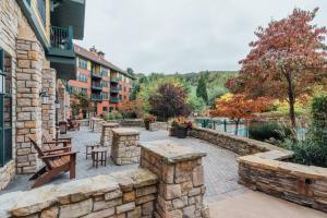 a patio with a stone wall and tables and benches at Mt. Slope Great View 1 Bed Condo in Vernon Township