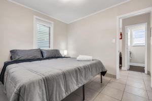 a white bedroom with a bed and two windows at Boutique Hotel Style Steps to Boardwalk in Seaside Heights