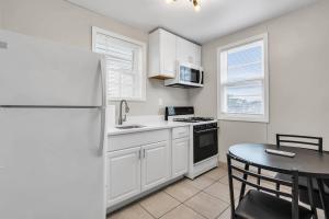 a kitchen with a white refrigerator and a table at Boutique Hotel Style Steps to Boardwalk in Seaside Heights