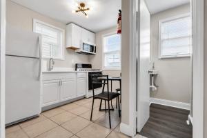a kitchen with a table and a refrigerator at Boutique Hotel Style Steps to Boardwalk in Seaside Heights +7 photos