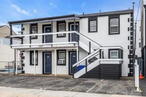 a white house with a staircase in front of it at Boutique Hotel Style Steps to Boardwalk in Seaside Heights