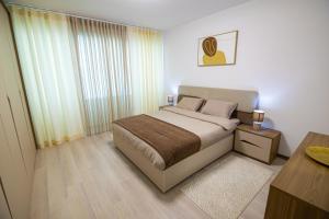 a bedroom with a large bed and a table at DEX Apartment Korca in Korçë