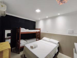 a room with two beds and a bunk bed at Essenza Suites Natal in Natal