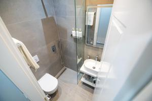 a bathroom with a shower and a toilet and a sink at DEX Apartment Korca in Korçë