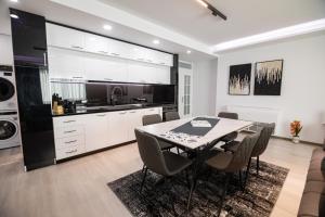 a kitchen and dining room with a table and chairs at DEX Apartment Korca in Korçë