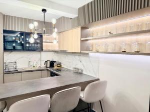 a kitchen with a counter with white chairs in it at Varja 3 Apartment in Pržno +15 photos