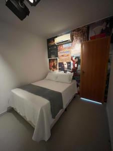 a small bedroom with a bed and a wall with posters at Flats Temáticos - By Temporada Expert - Conforto e Climatizado in Feira de Santana