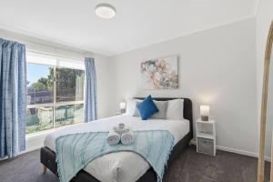a bedroom with a large bed and a window at Tranquil Escape by the Water in Triabunna