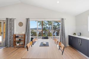 a kitchen and dining room with a table and chairs at Tranquil Escape by the Water in Triabunna