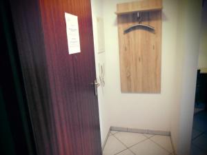 a bathroom with a brown door and a wooden cabinet at Ferienwohnung Wehr in Filderstadt
