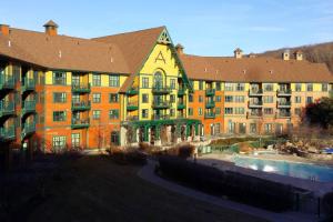a large building with a pool in front of it at 2 Bed Top Flr Prem Penthouse Suite in Vernon Township