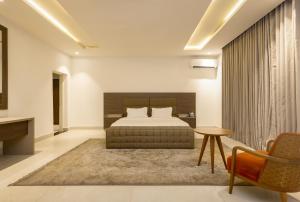 a bedroom with a bed and a table and a chair at D'Crown Place in Abuja +80 photos