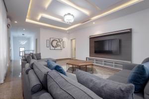 a living room with a couch and a flat screen tv at D'Crown Place in Abuja